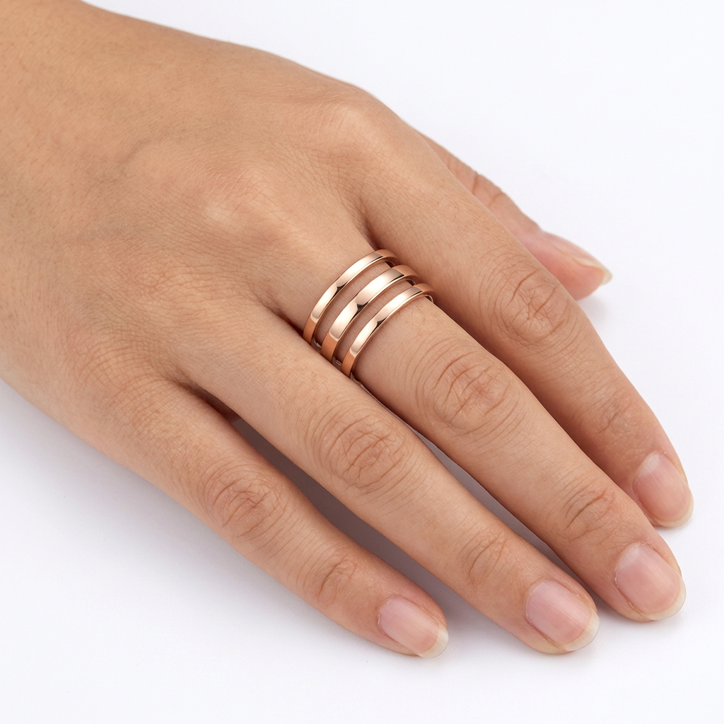 Jeden złoty pierścionek z trzema pasmami na dłoni modelki na białym tle